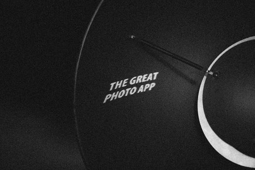 Black and white photo of 'The Great Photo App' text projected on a dark surface.