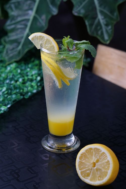 Free Tall glass of lemonade with mint and lemon slices on a patterned surface. Stock Photo