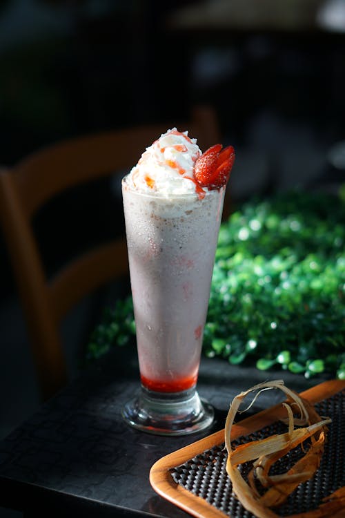 Free Milkshake in a Glass with Whipped Cream and Strawberry on Top Stock Photo