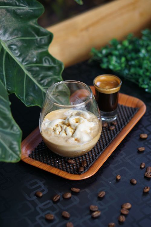 Free Tantalizing iced coffee and espresso on a wooden tray surrounded by coffee beans. Stock Photo
