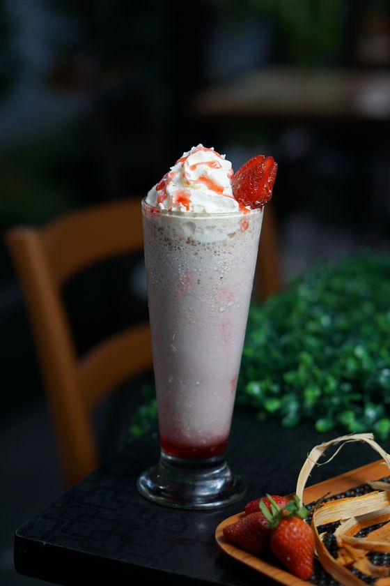 Strawberry milkshake overflowing with whipped cream