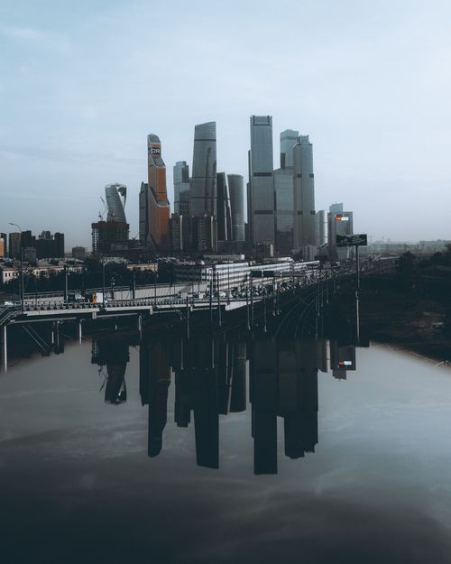 Free Gloomy Moscow skyline showcasing high-rise skyscrapers reflecting in calm water. Stock Photo