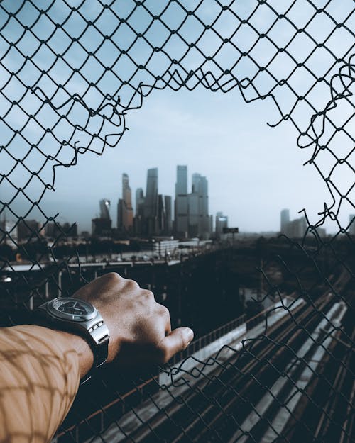 Free View on the City through the Whole in the Wire Mesh Stock Photo