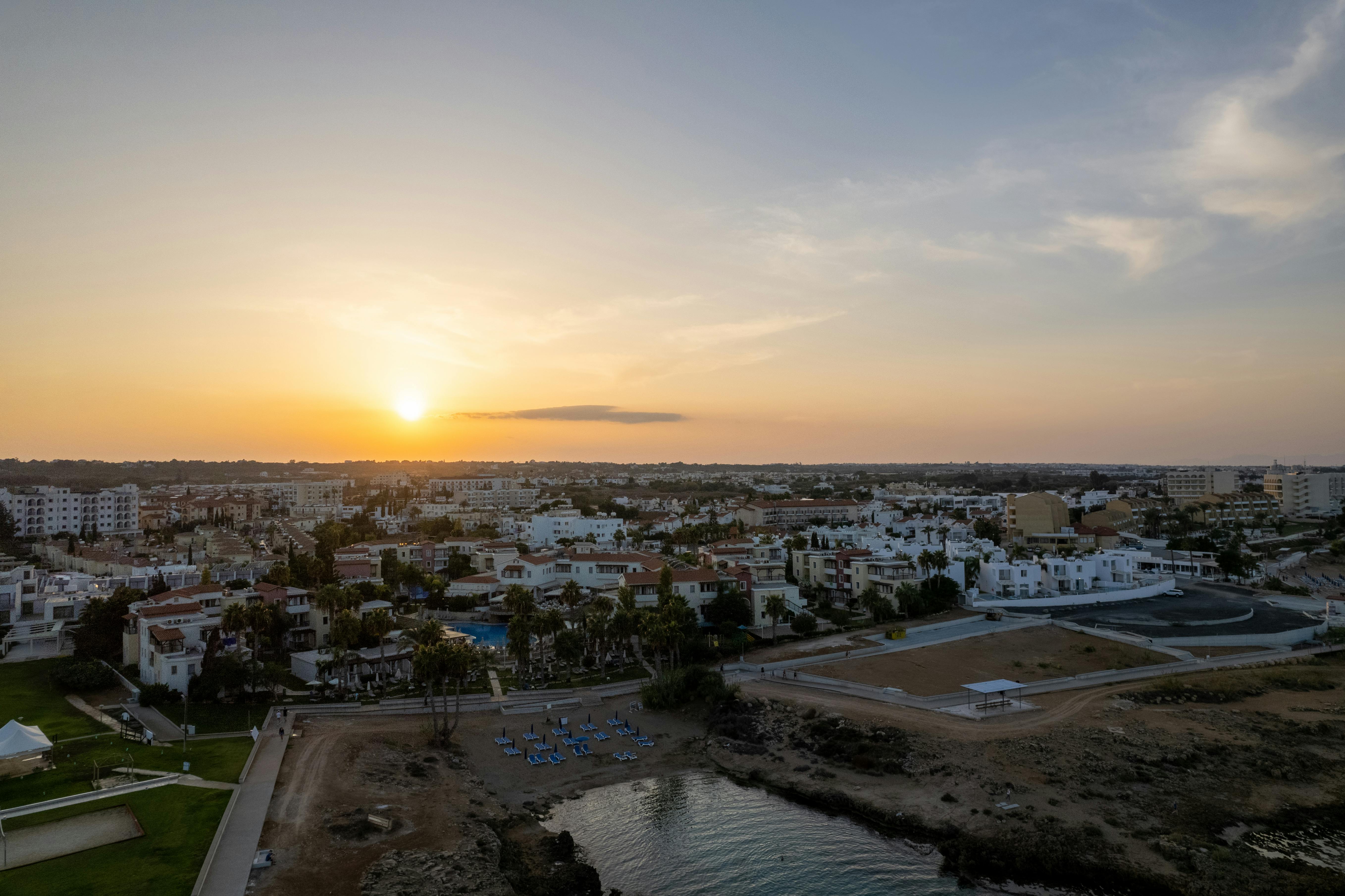 Aerial view of Pernera, Famagusta at sunset, featuring a serene shoreline and vibrant townscape. - Photo by Ollie Craig on Pexels