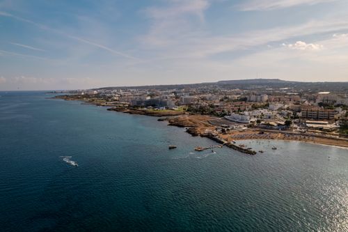 Free Stunning aerial view of Pernera coastline in Cyprus with vibrant blue waters and cityscape. Stock Photo