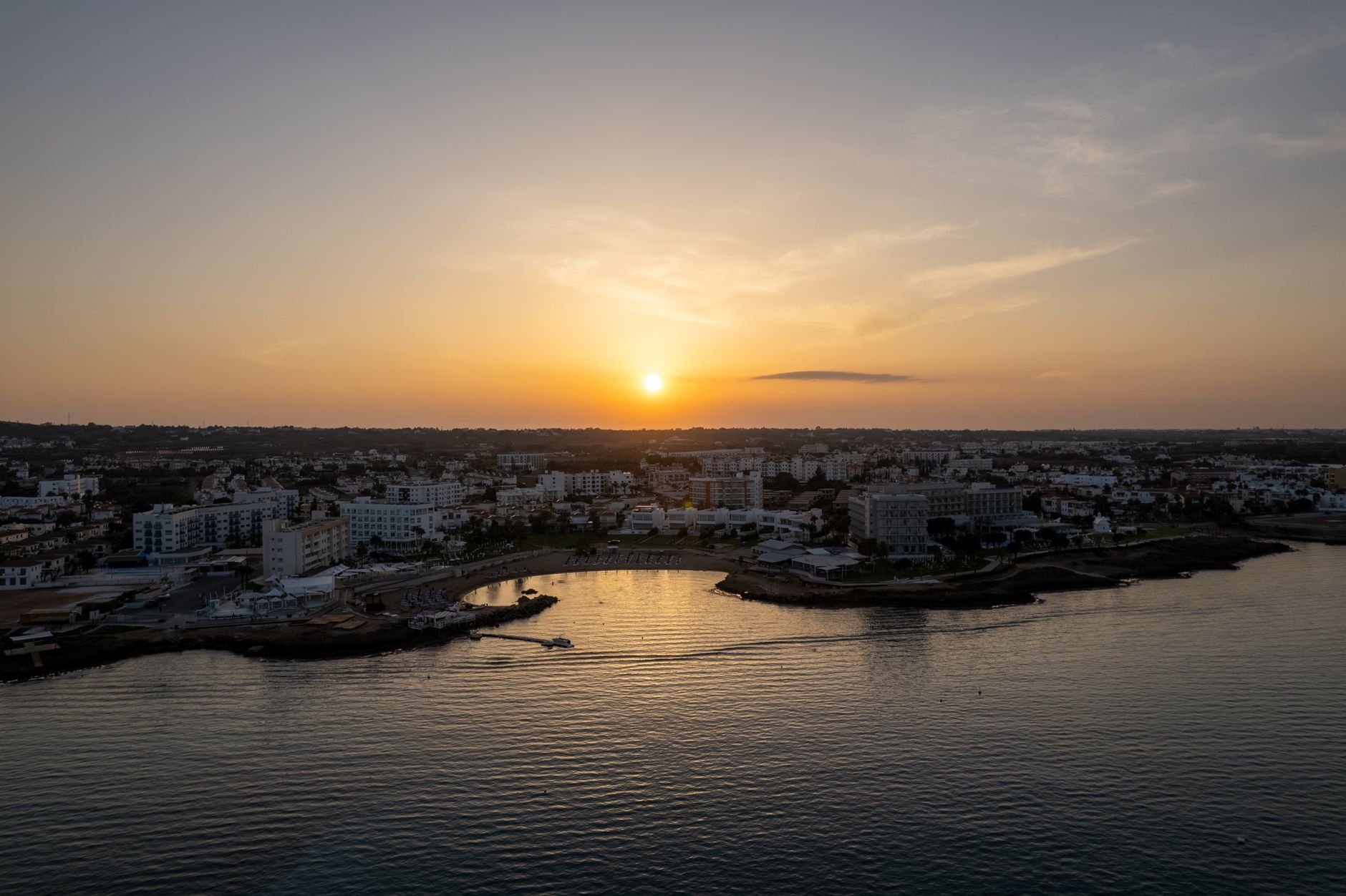 Sea-view balconies above a sandy bay on the Cyprus coast at sunrise