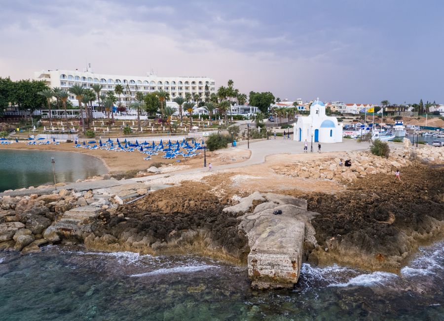 Aerial view of a church near the beach in Pernera, Cyprus, capturing the serene coastal landscape.