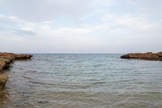 A serene coastal scene capturing calm waters merging with the clear blue sky.