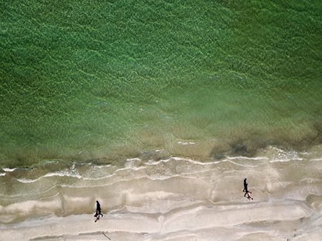 Drone shot of people walking on the pristine sandy beach of Cervia, Italy.