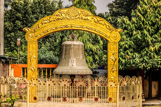 Giant engraved bell at Mulagandhakuti Vihara with ornate details in Sarnath, India.