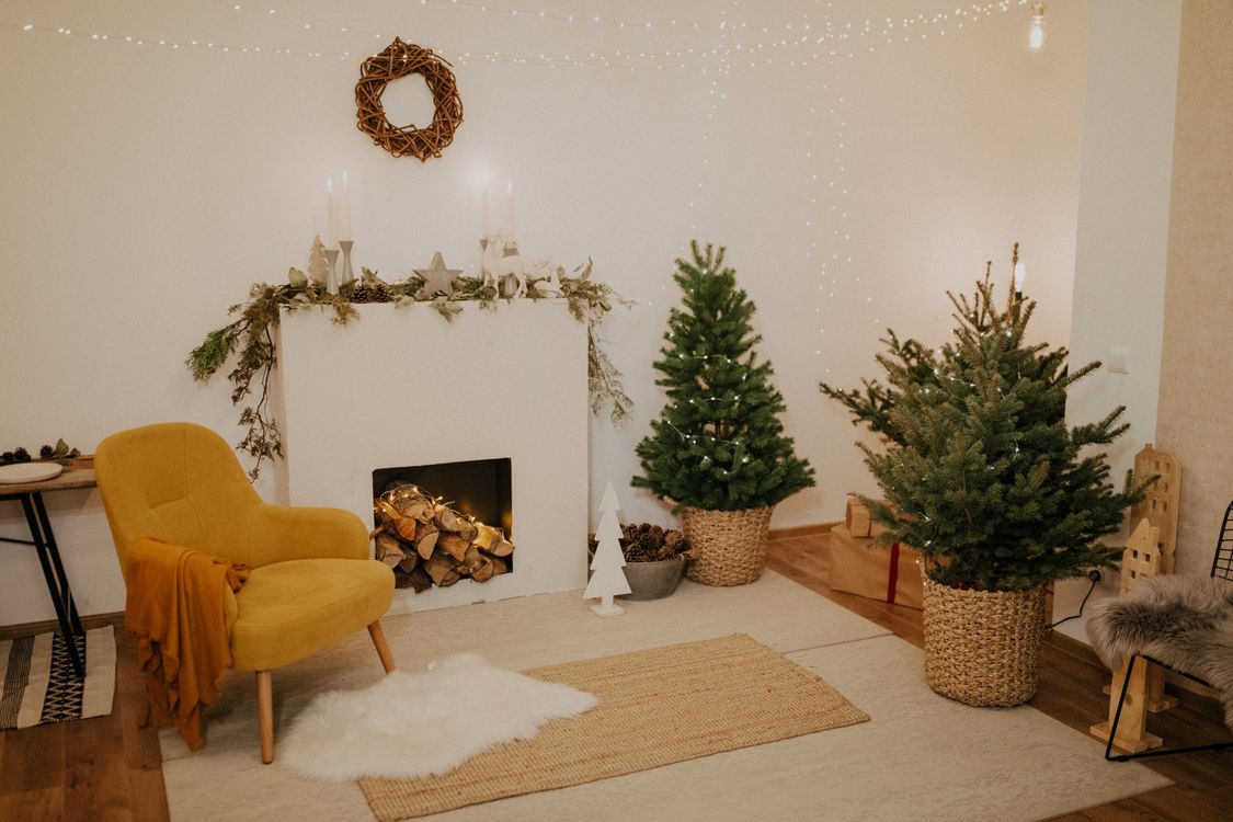 rustic-farmhouse-christmas Rustic farmhouse Christmas living room with small real trees in baskets and a white fireplace