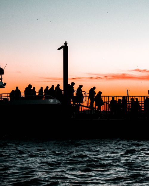 Free Silhouette of people enjoying a stunning sunset by the water in İstanbul. Stock Photo