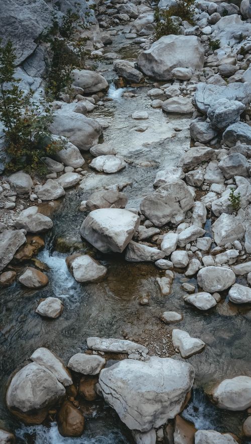 Free A tranquil stream with large rocks in a natural outdoor setting, perfect for nature lovers. Stock Photo