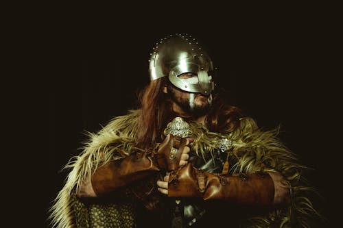 Viking in Costume with Sword on Black Background