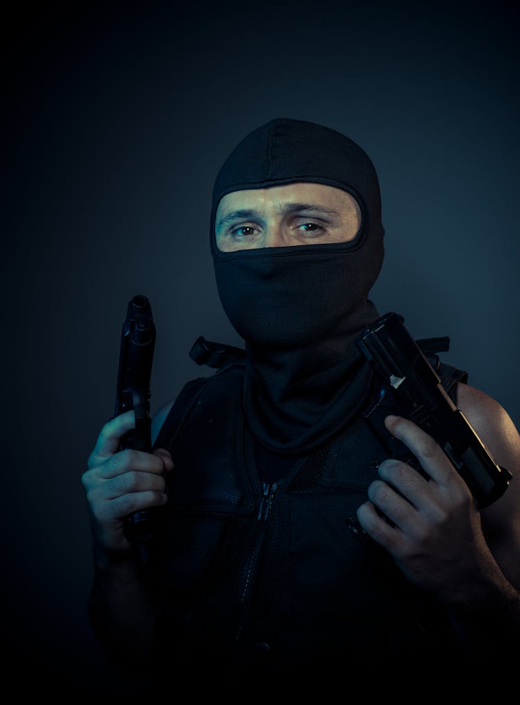 Man In Mask Holding Guns