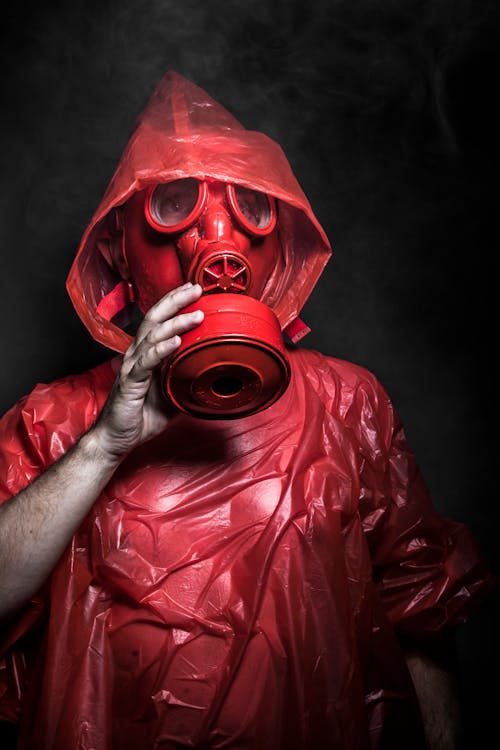 Free Man in Red Plastic Jacket Wearing Red Gas Mask Stock Photo