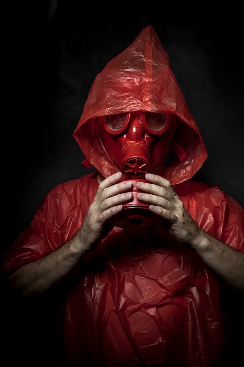 Free Man in Red Plastic Jacket Wearing Red Gas Mask Stock Photo