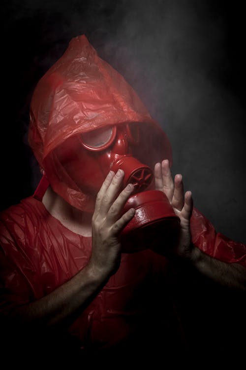 Free Man in Red Gas Mask and Red Plastic Hood Stock Photo