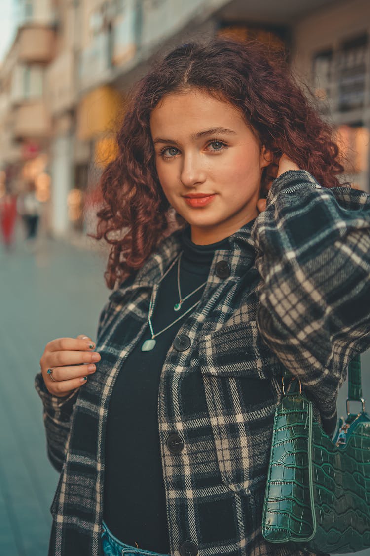 Woman In Black And White Plaid Flannel Shirt With Green Leather Handbag