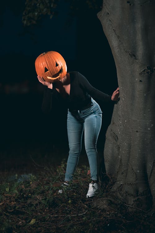 A Woman Wearing a Carved Pumpkin on Head 
