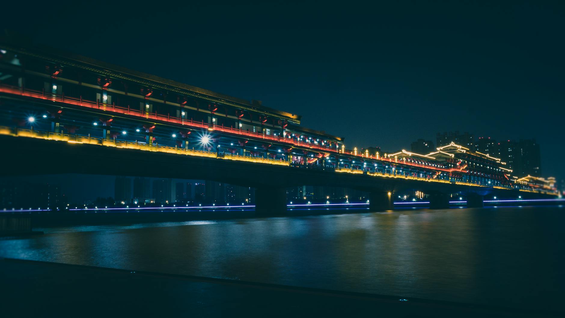Illuminated Bridge Over the River During Night Time