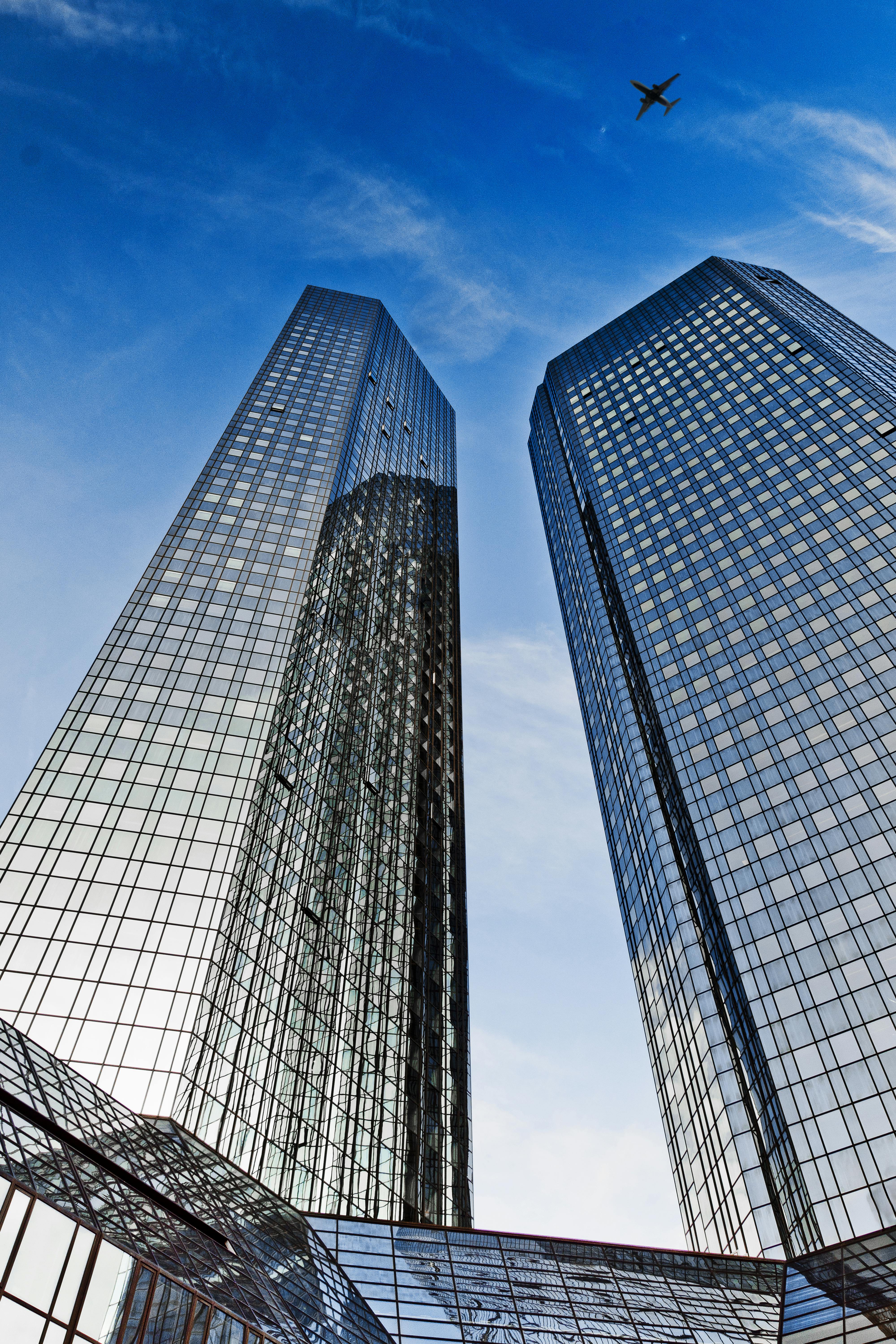 an airplane flying above deutsche bank twin towers