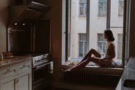 Woman in White Dress Sitting by the Window