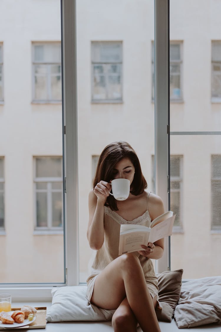 Woman In Beige Dress Drinking From White Ceramic Mug