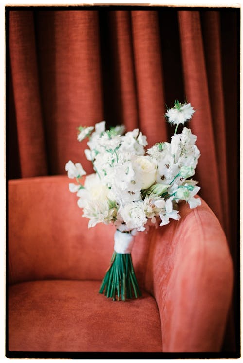 Bouquet of White Flowers on Red Sofa