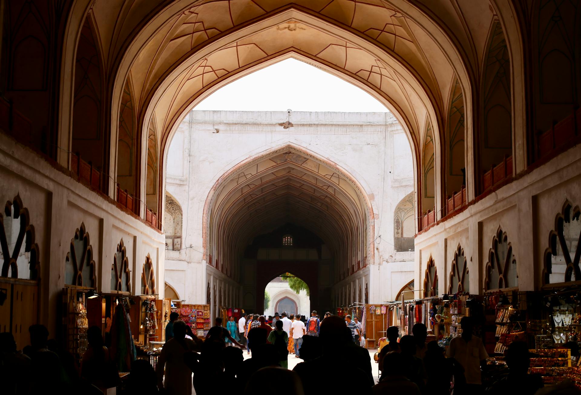 Vibrant scene of shoppers in a historic Indian arcade, capturing cultural architecture and lively market atmosphere.