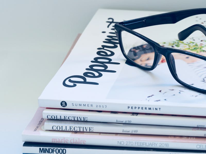 Eyeglasses on a stack of fashion and lifestyle magazines including Peppermint and Collective.