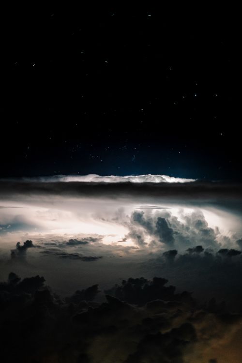 Free Cinematic view of a thunderstorm with stars visible in the night sky, showcasing nature's raw power. Stock Photo