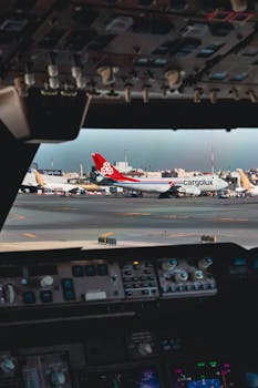 View from an aircraft cockpit overlooking a Cargolux cargo plane on the airport tarmac.
