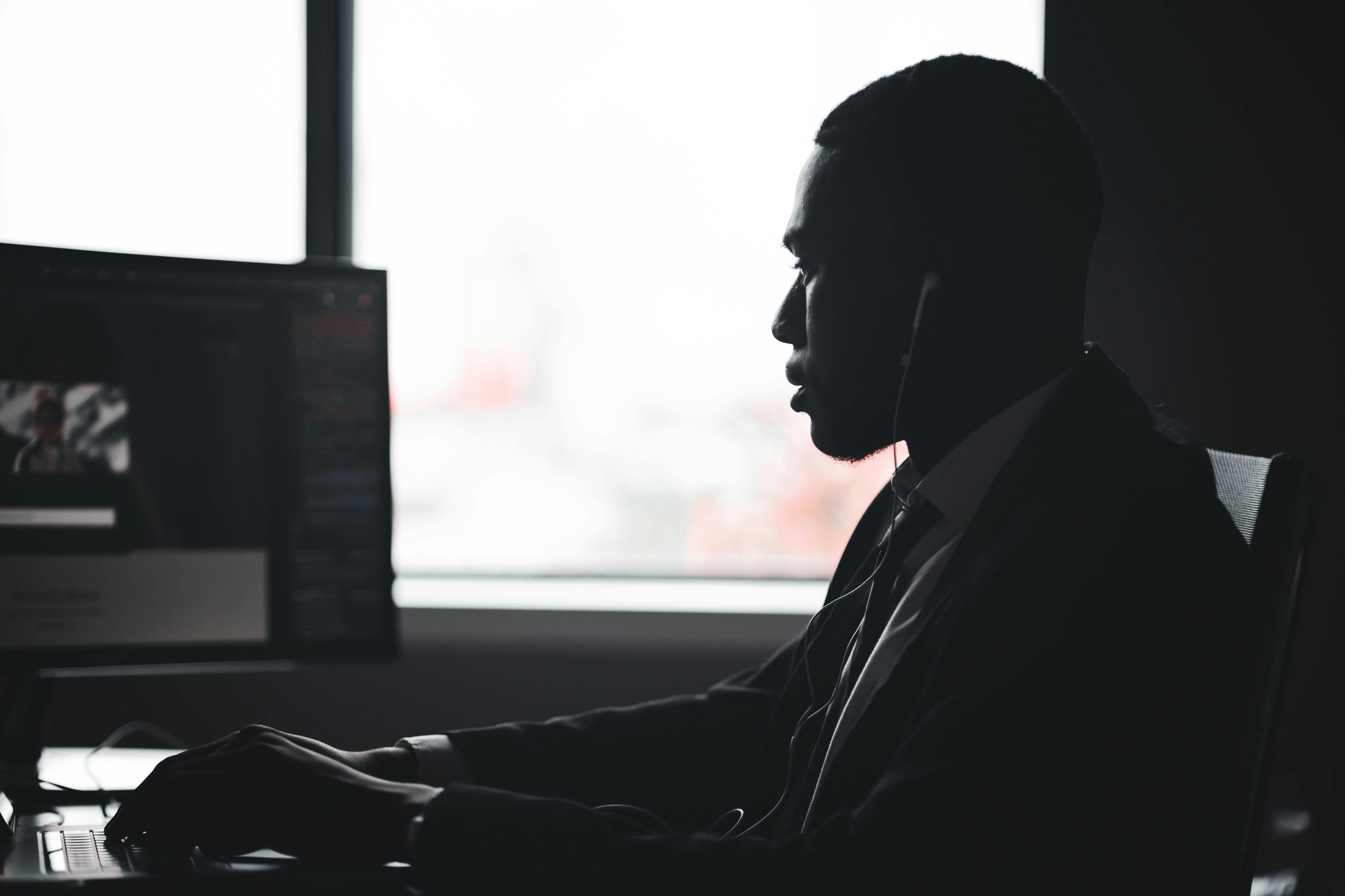 Man sitting at desk with computers in office · Free Stock Photo