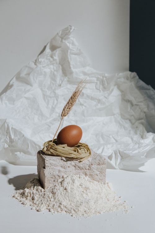 Free Artistic display of flour, egg, and wheat in a rustic kitchen style. Stock Photo
