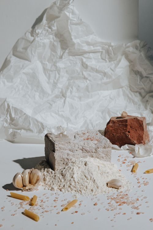 Free Artistic still life featuring raw pasta, garlic, flour, and rock salt for Italian culinary inspiration. Stock Photo