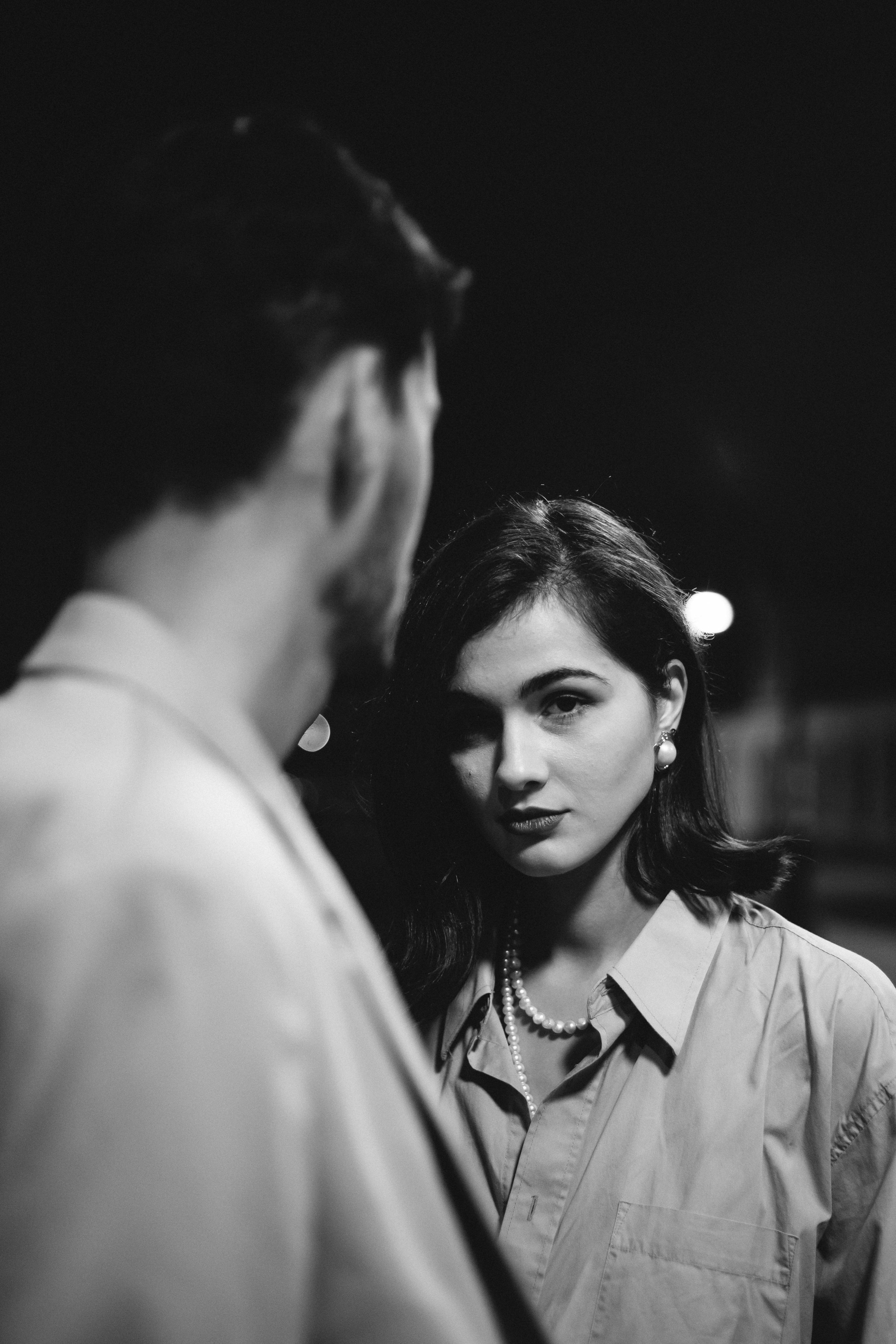 a grayscale photo of a woman standing beside her partner