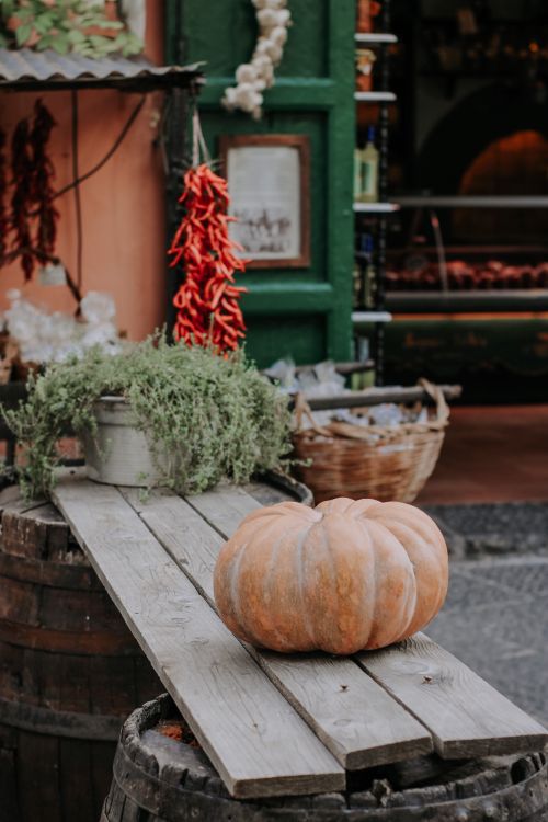 Free Cozy autumn market setup featuring a pumpkin on a wooden table outdoors. Stock Photo