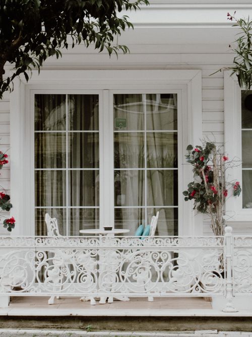 Free Elegant white balcony with intricate railing and blooming flowers in Istanbul, Turkey. Stock Photo