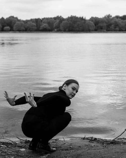 A Woman in Black Sitting Near the River