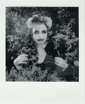 Monochrome double exposure portrait of a woman blended with floral textures, creating a mysterious effect.