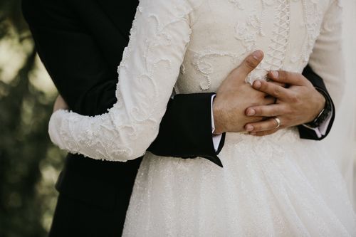 Free Close-up of a couple embracing in wedding attire, showcasing love and commitment. Stock Photo