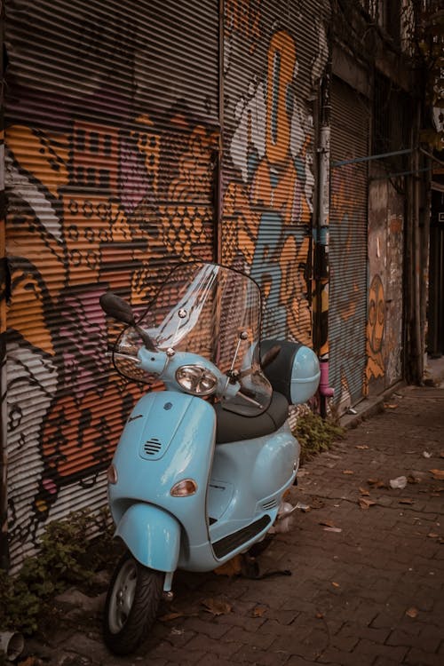 A Blue Vespa Scooter Parked on the Street