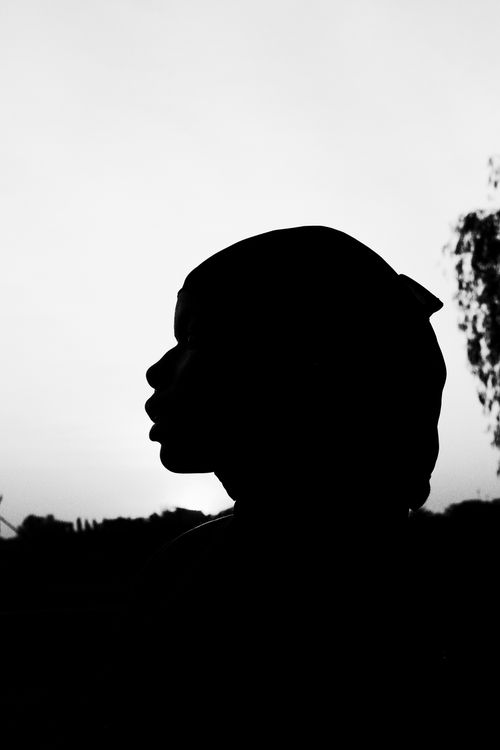 Free A black and white silhouette of a woman during sunset in Nigeria, capturing serene beauty and elegance. Stock Photo