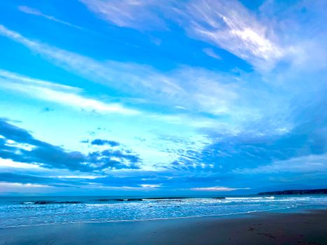 Peaceful seashore scene with blue sky and cloud formations in Filey, England.