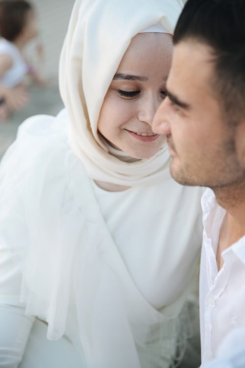 Free A close-up portrait of a romantic couple, featuring a woman in a hijab, embracing softly. Stock Photo
