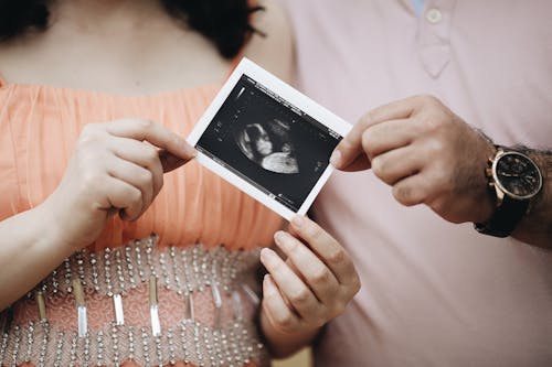 Free Close up on Pregnancy Photograph in Couples Hands Stock Photo