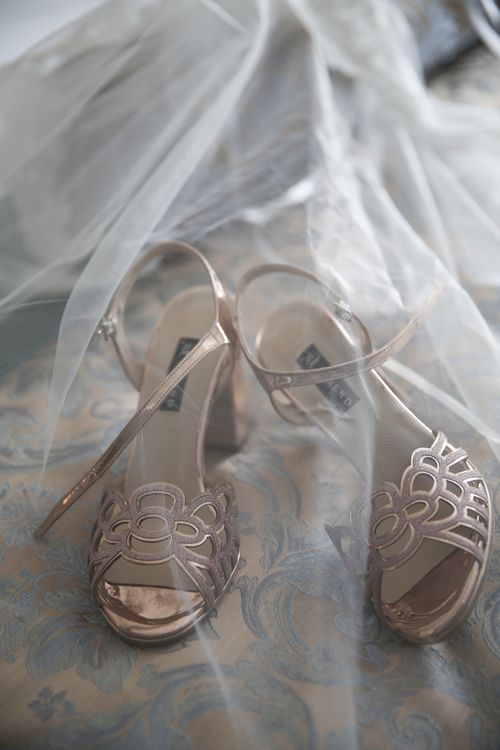 Free Close-up of stylish bridal shoes under a wedding veil on a decorative lace backdrop. Stock Photo