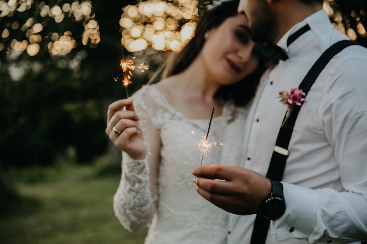 Bride And Groom Holding Sparklers In Hands