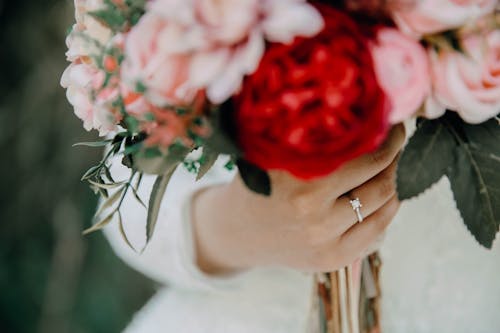 Free A Woman Wearing a Silver Ring while Holding a Bouquet of Flowers Stock Photo